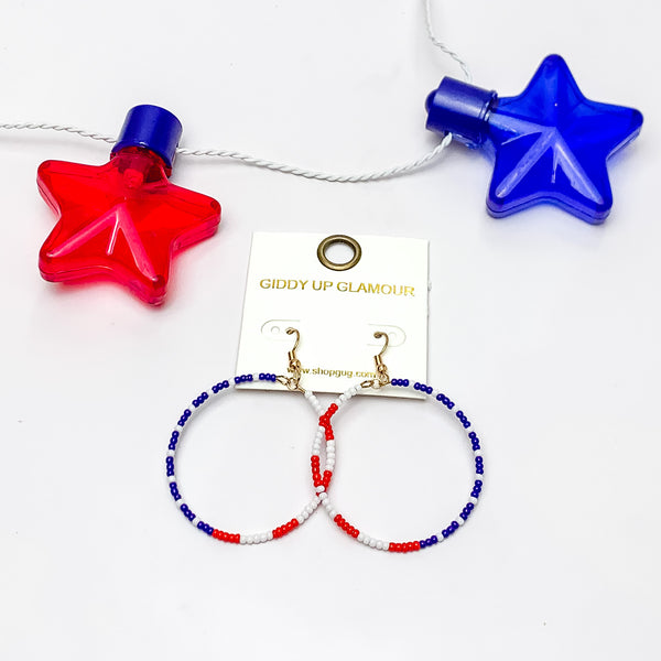 Red, White, And Blue Beaded Circle Earrings. Pictured on a white background with a red and blue star above the earrings.