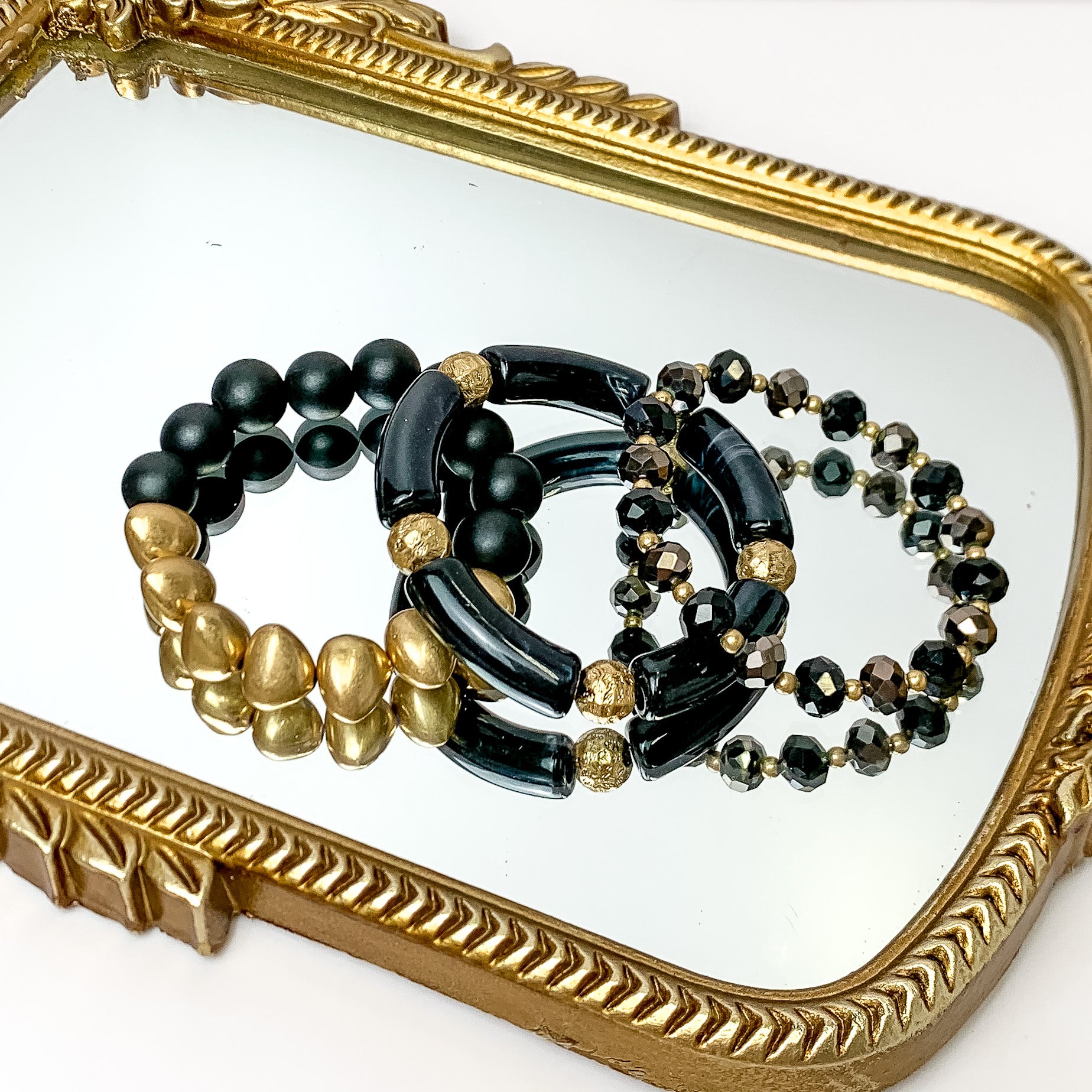Set of Three | Island Dream Crystal and Marble Beaded Bracelet Set in Black. Pictured on a white background laying on a mirror with a gold trim.