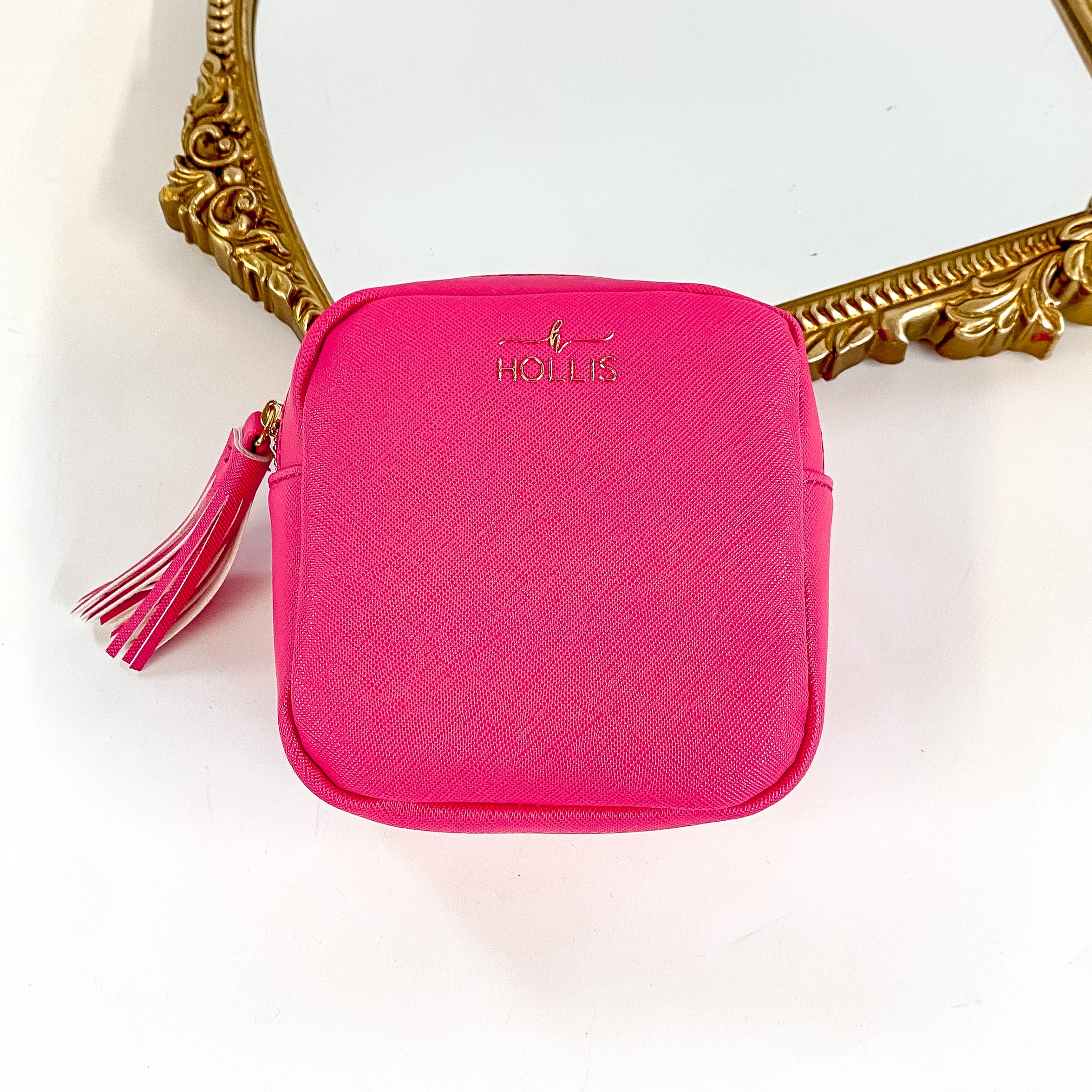 Hollis brand technology organizer in hot pink. Smaller square zip up bag. Pictured on a white background with a frame behind the bag.