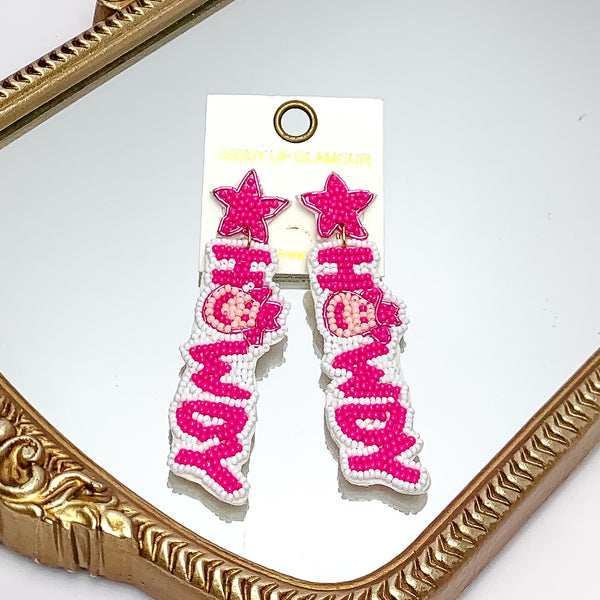 Beaded Howdy Earrings With Star Posts In Hot Pink. Pictured on a mirror with a gold trim.