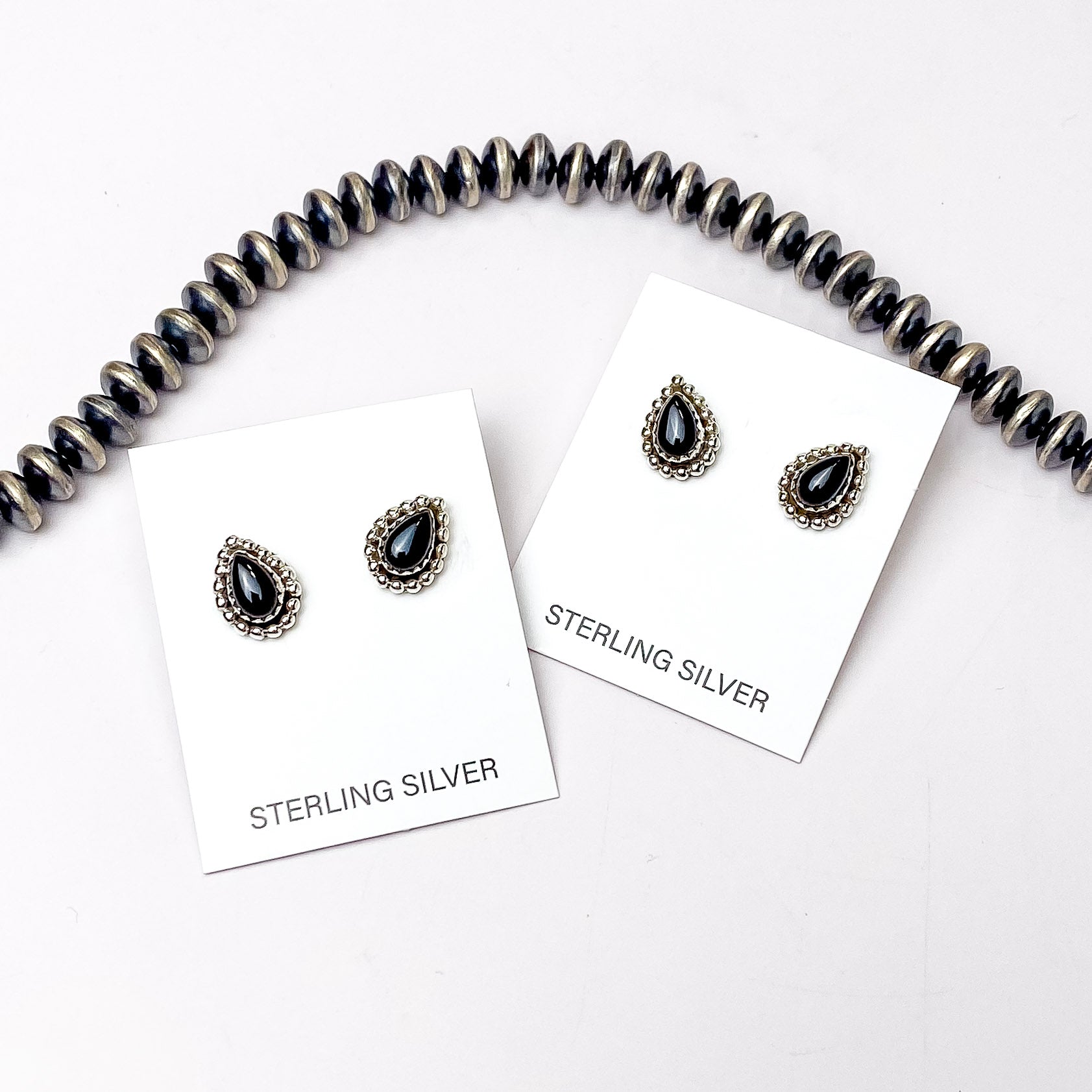 These gorgeous earrings include a sterling silver teardrop shaped setting with black onyx  stones in the center with a white background