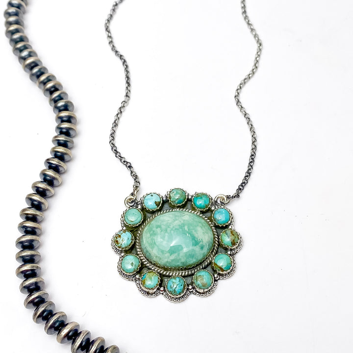 In the picture is a gorgeous handmade sterling silver flower shaped cluster with a circle center in a remix multi-stone color with a white background