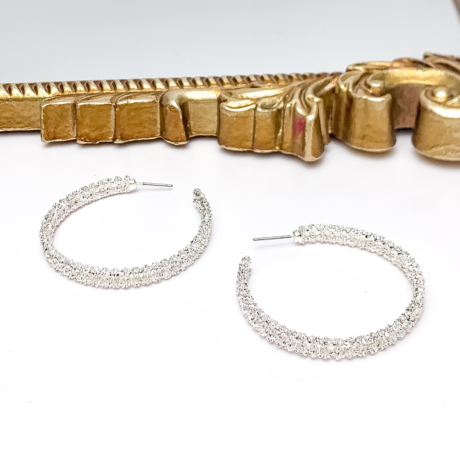 Worry Free Large Silver Tone Textured Hoop Earrings. Pictured on a white background with a gold frame above the earrings.