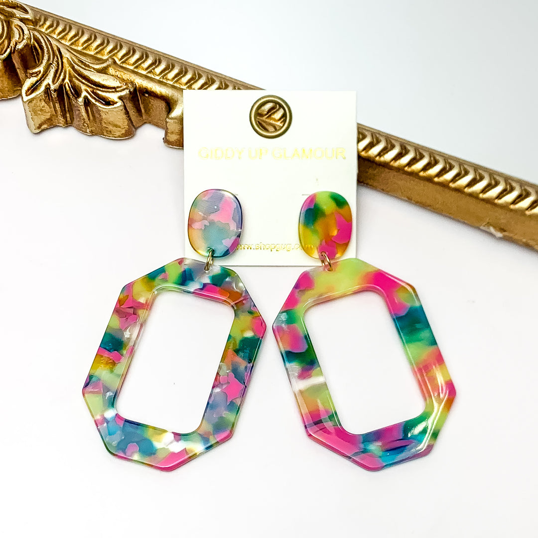 Malibu Marble Open Rectangle Earrings in Pink and Green Multicolor. Pictured on a white background with the earrings laying on a gold frame.