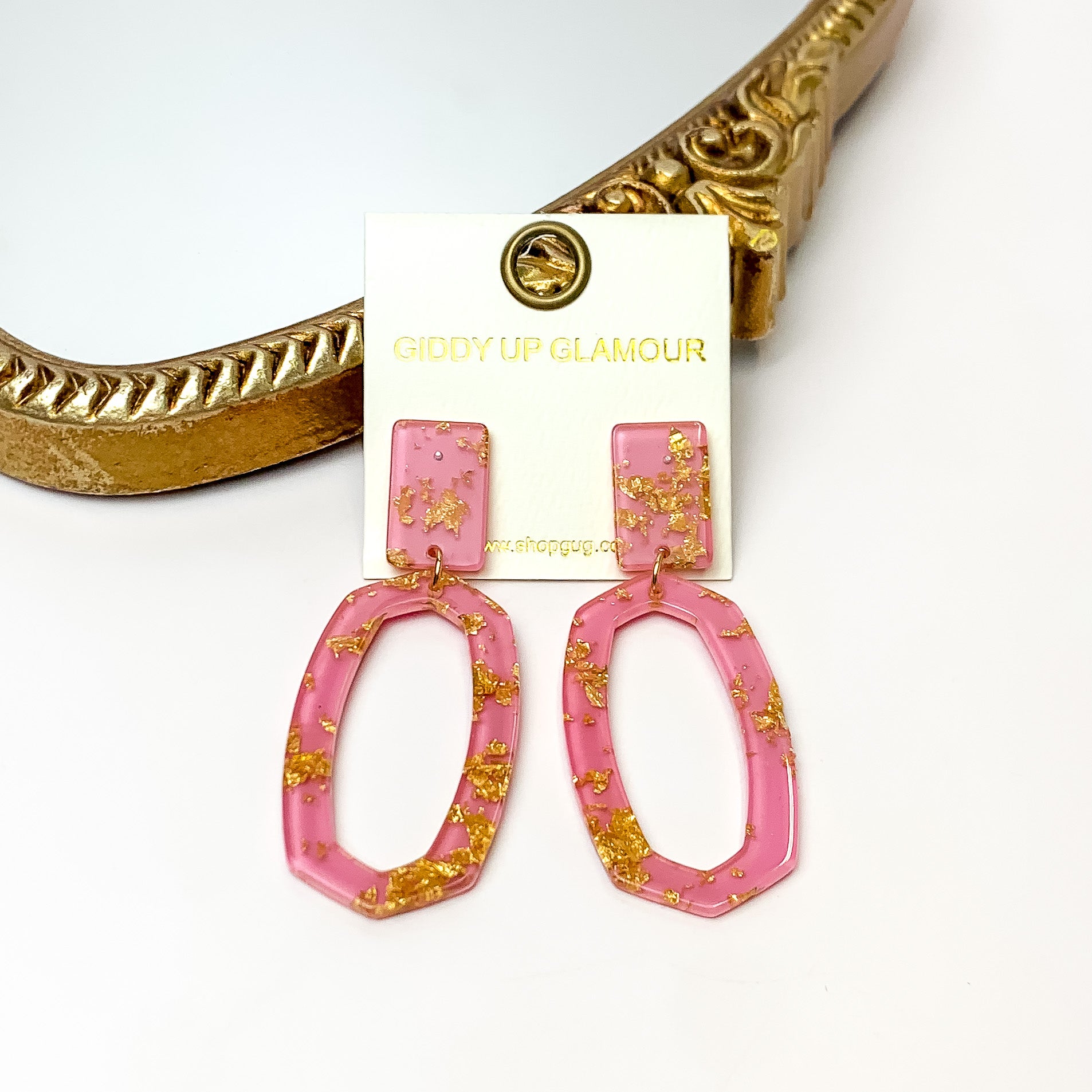 Miami Marble Open Oval Earrings in Pink. Pictured on a white background with the earrings against a gold frame.