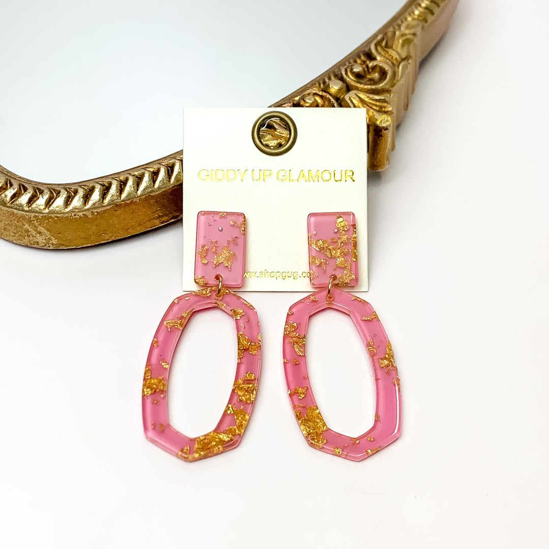 Miami Marble Open Oval Earrings in Pink. Pictured on a white background with the earrings against a gold frame.