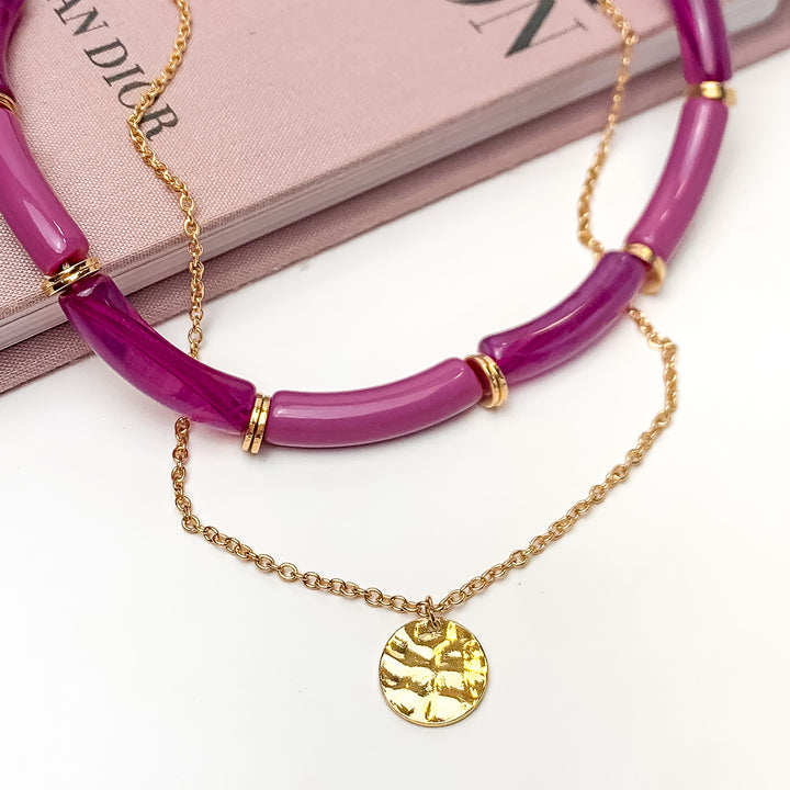 Perfect Paradise Tube Necklace With Second Gold Tone Chain Necklace In Purple. Pictured on a white background with the necklace laying on a book.