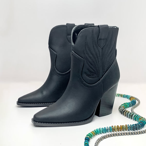 Not My First Rodeo Western Stitch Heeled Ankle Booties in Black. Pictured on a white background with jewelry pieces laying on the platform.