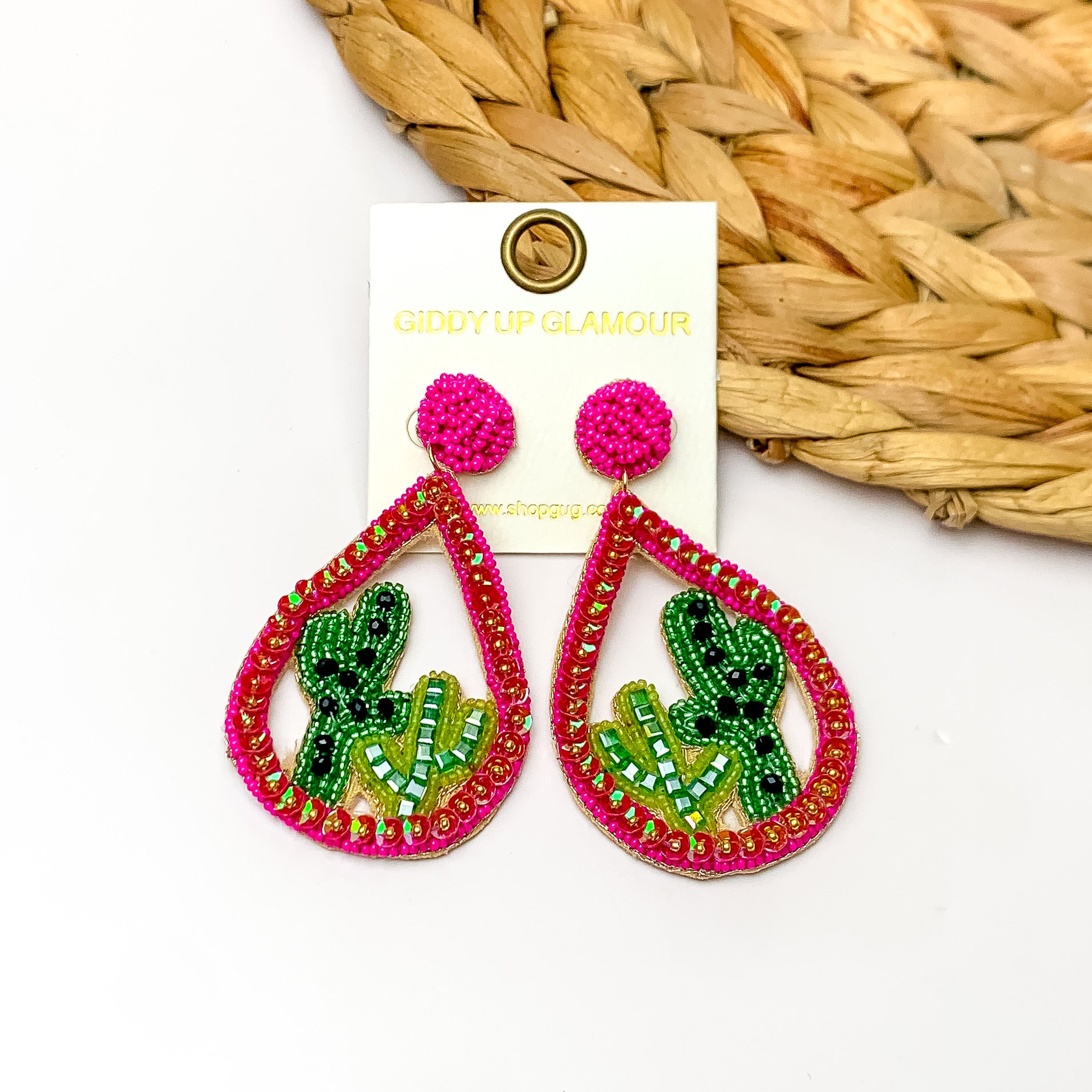 Beaded Open Teardrop Earrings With Cactus Scene on the Inside in Hot Pink. Pictured on a white background with a brown decoration in the top right corner.