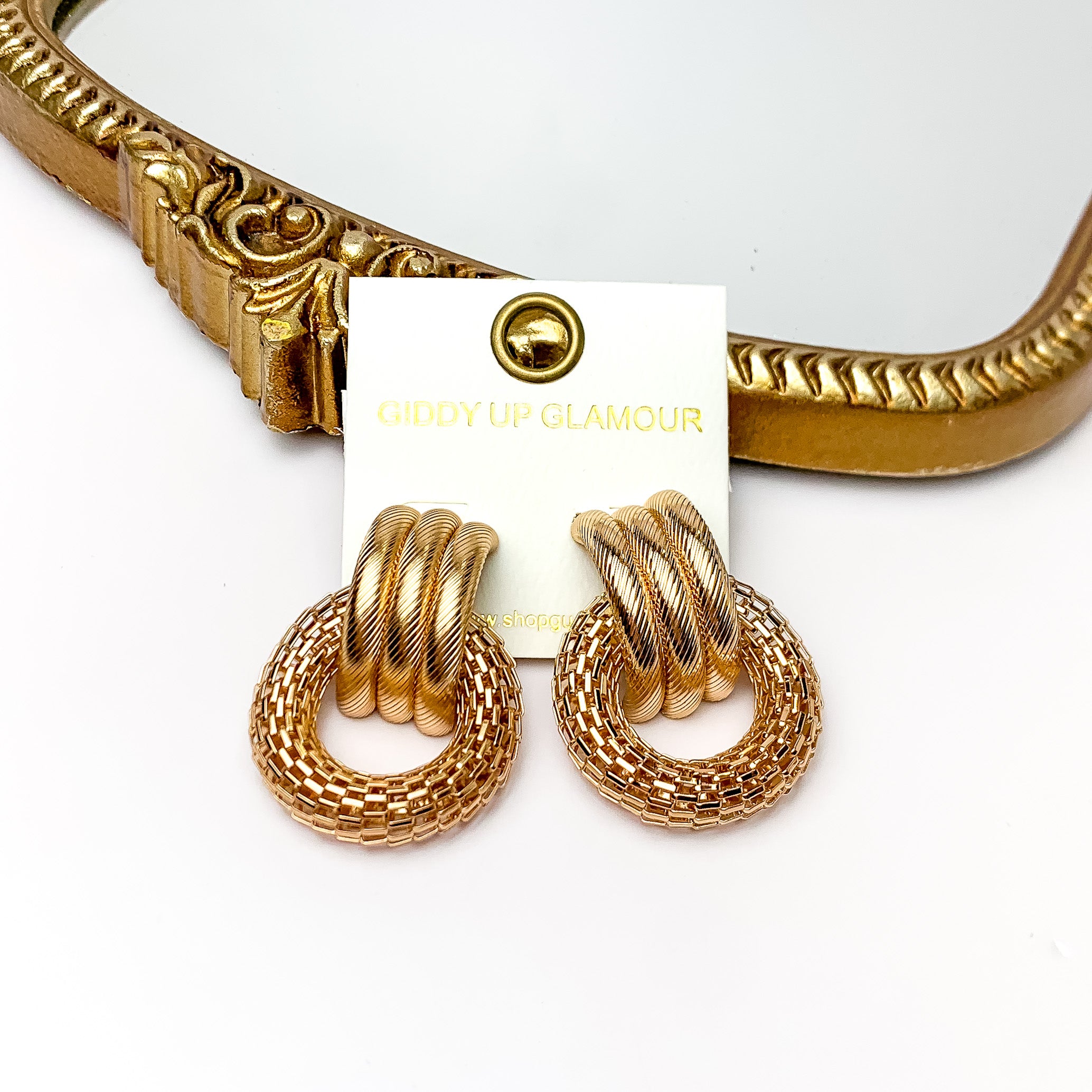 Gold Tone Textured Circle Post Earrings. Pictured on a white background with a gold frame above the earrings.