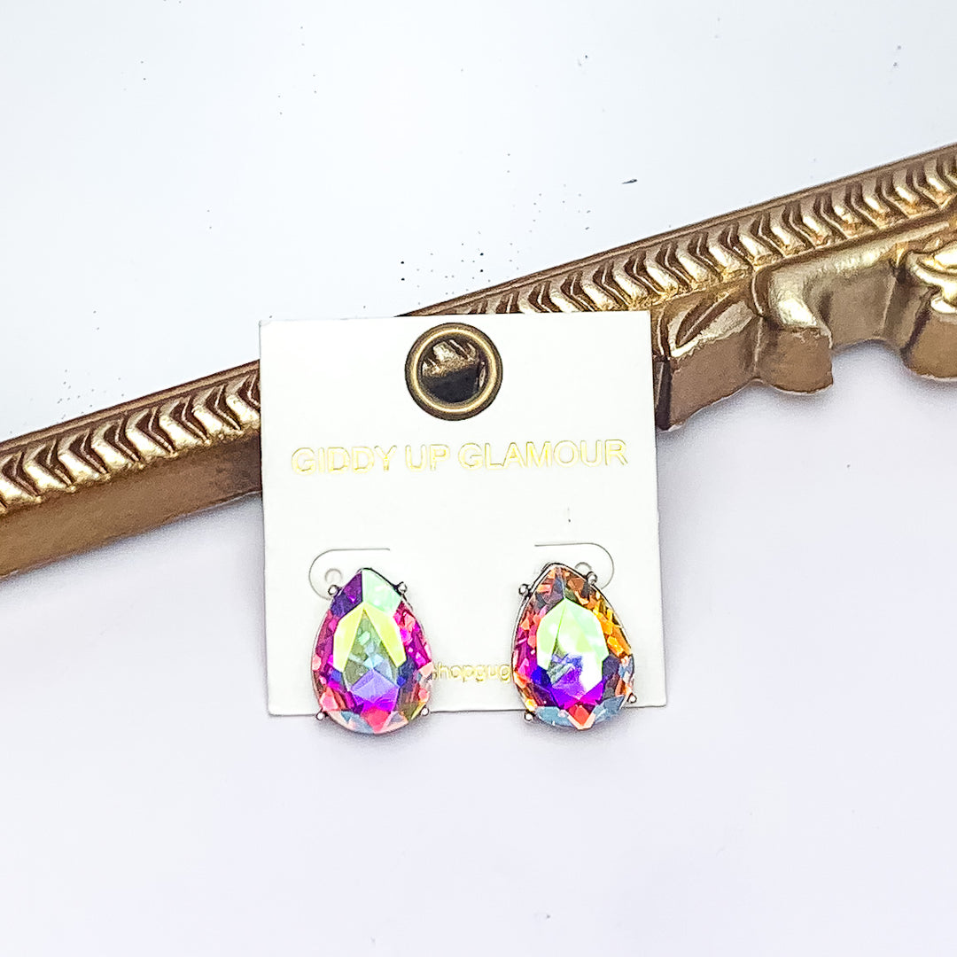 Teardrop Stud Earrings With AB Crystals in Silver Tone. Pictured on a white background with a gold frame behind the earrings.