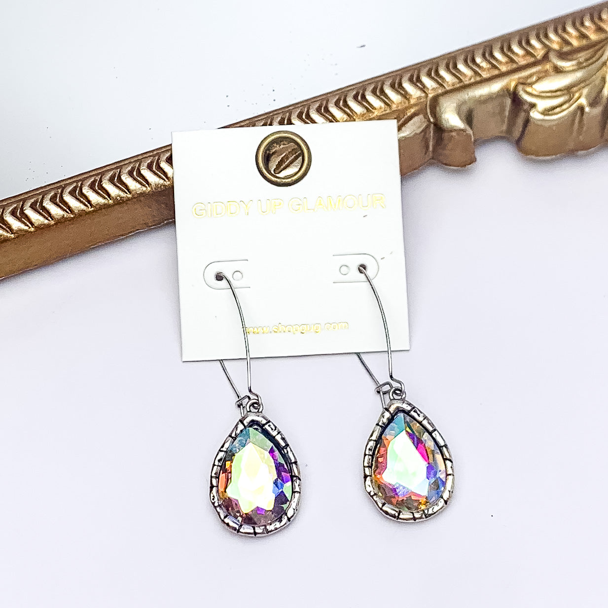 Radiant Kidney Wire Teardrop Earrings With AB Crystals in Silver Tone. Pictured on a white background with a gold frame in the background.