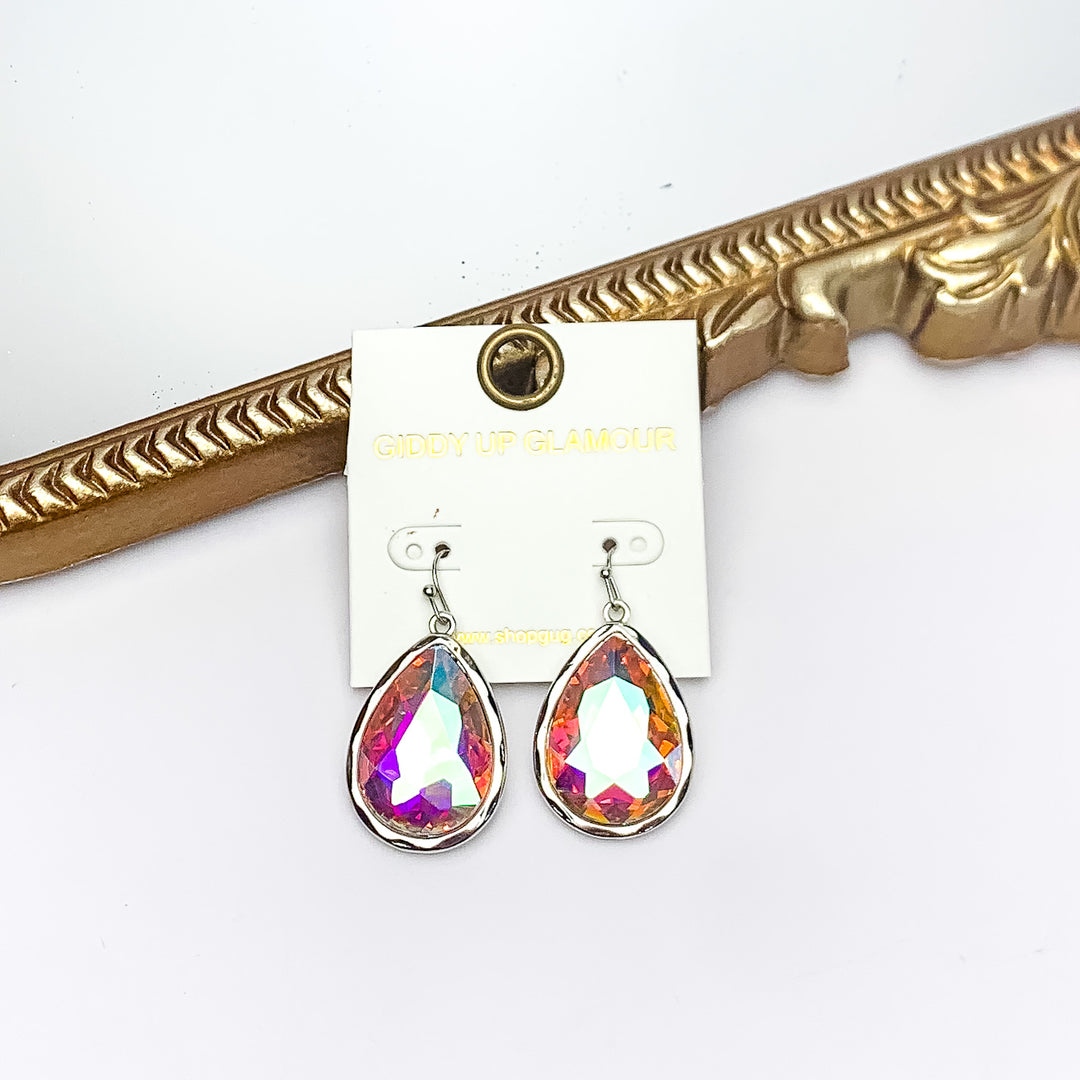 Gold Tone Large Teardrop Earrings With AB Crystals. Pictured on a white background with a gold frame behind the earrings.