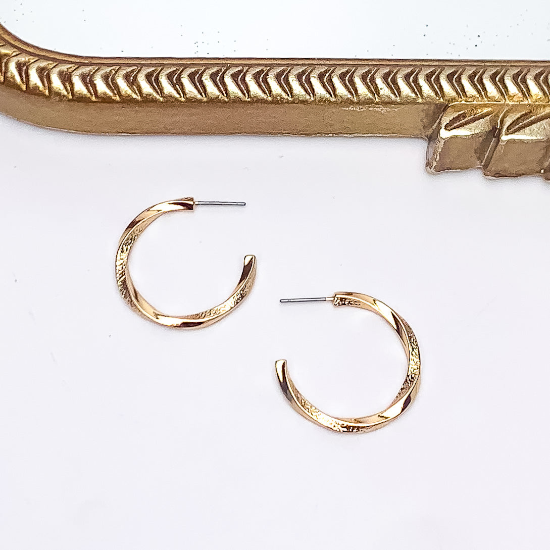 City Day Small Gold Tone Hoop Earrings. Pictured on a white background with a gold frame above the earrings.