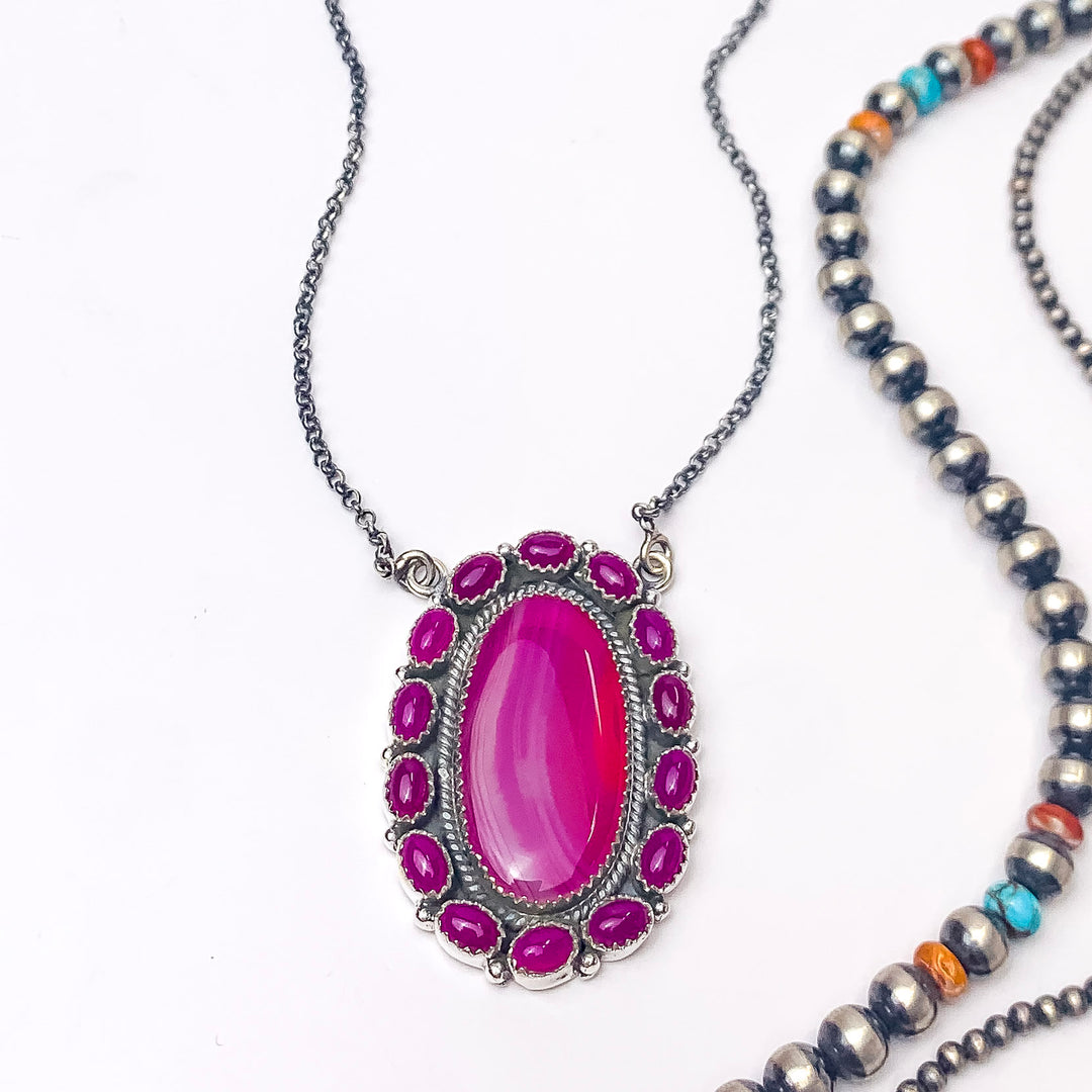 In the picture is a handmade sterling silver opal center with outside circle clusters around it in the color multi stone with a white background