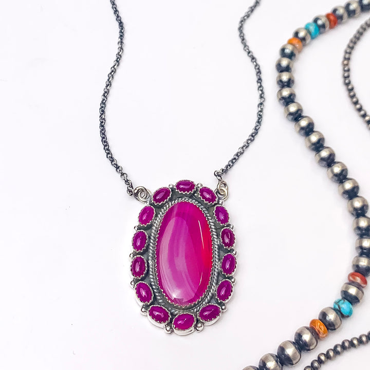 In the picture is a handmade sterling silver opal center with outside circle clusters around it in the color multi stone with a white background