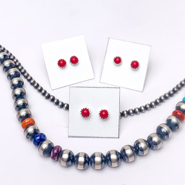 In the picture are stud red corral earrings with a white background