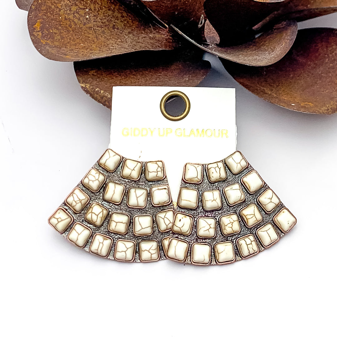 Western Trapezoid Shape Copper Tone With Stones in Ivory. Pictured on a white background with a metal flower behind the earrings.