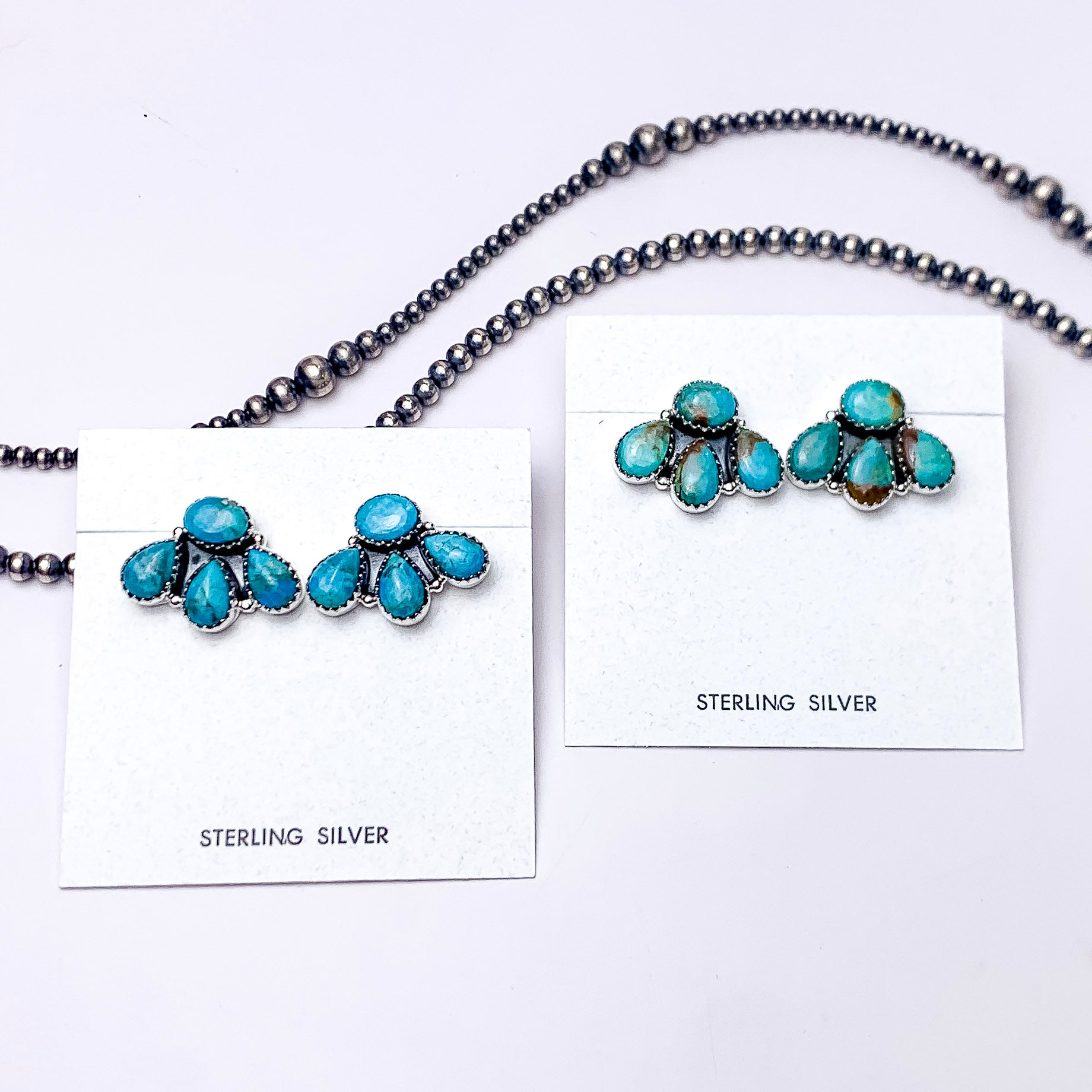 In the picture are sterling silver circle cluster earrings in the the color kingman turquoise with a white background  