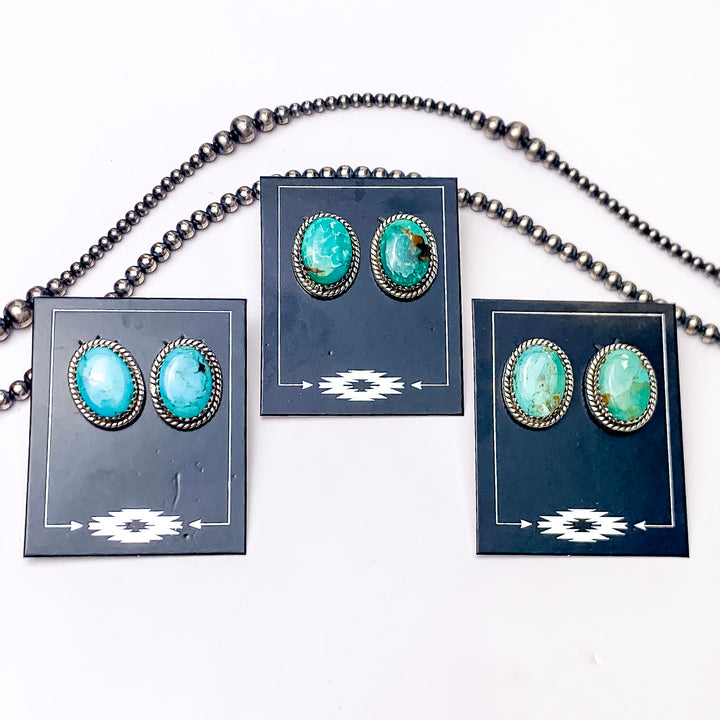 In the picture are handmade sterling silver oval stud earrings with kingman turquoise stones with a white background