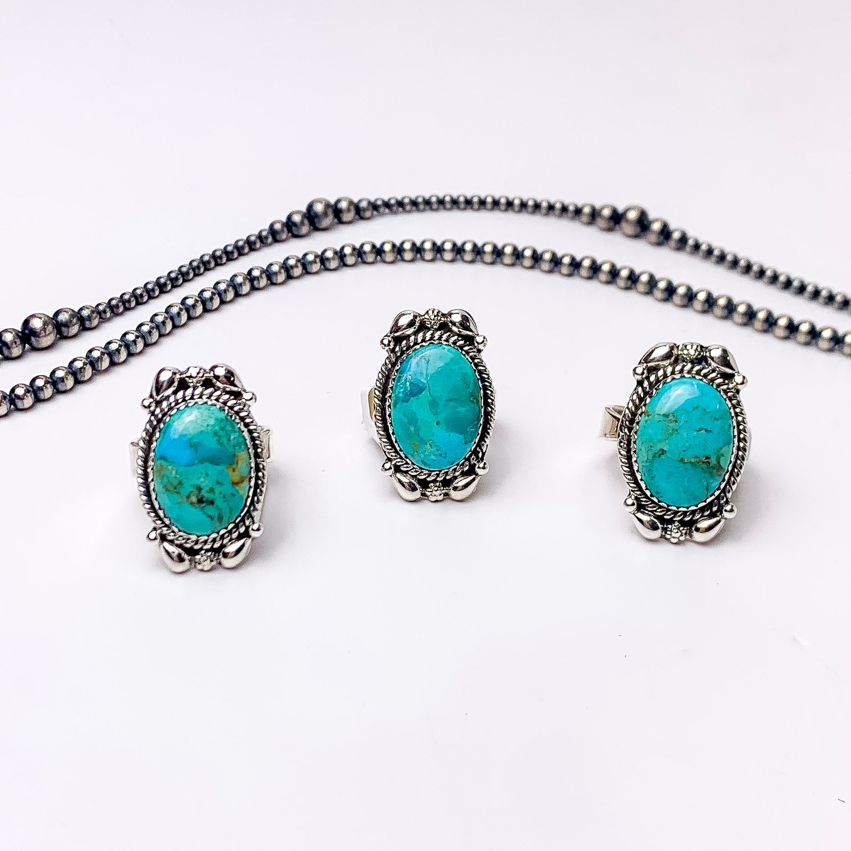 In the picture are three oval shaped partial desgin rings in the color kingman turquoise with a white background 
