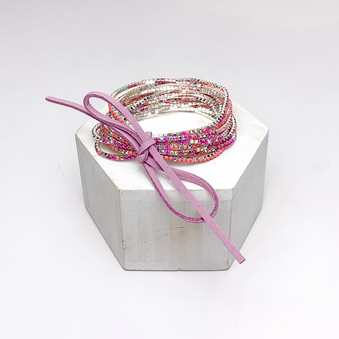 Day Party Crystals Stretchy Bracelet Set With Bow in Light Pink. Pictured on a white background with the jewelry sitting on a white podium.