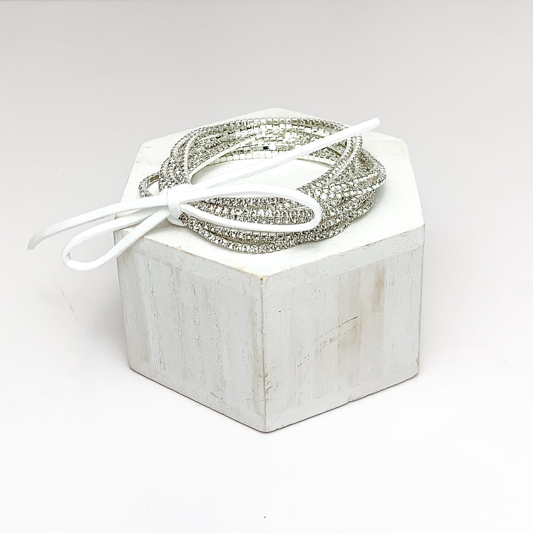 Day Party Crystals Stretchy Bracelet Set With Bow in Clear Crystals. Pictured on a white background with the bracelets on a podium.