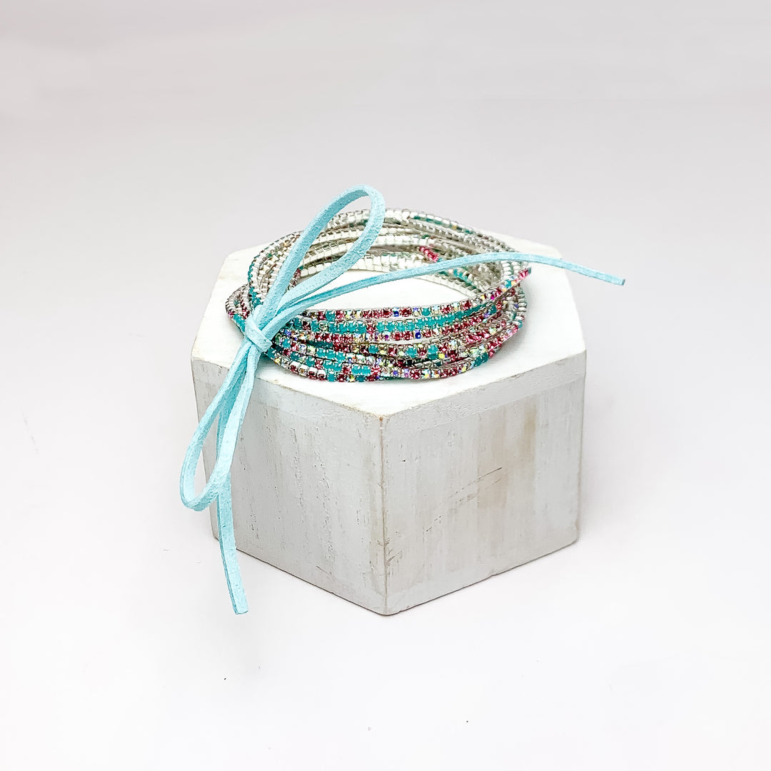 Day Party Crystals Stretchy Bracelet Set With Bow in Turquoise Blue. Pictured on a white background with the bracelets on a podium.
