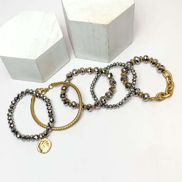 Set of Five | City Dreamer Gold Tone Bracelet Set in Silver Tone. Pictured on a white background with two white podiums behind the bracelets.
