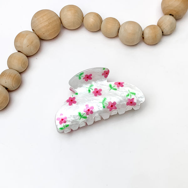 Flower Patch Hair Clip in White With Pink Flowers. Pictured on a white background with wood beads above the hair clip.