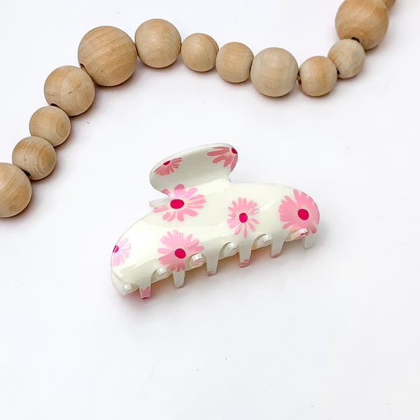 Flower Fields Hair Clip in Cream White. Pictured on a white background with wood beads above the hair clip.