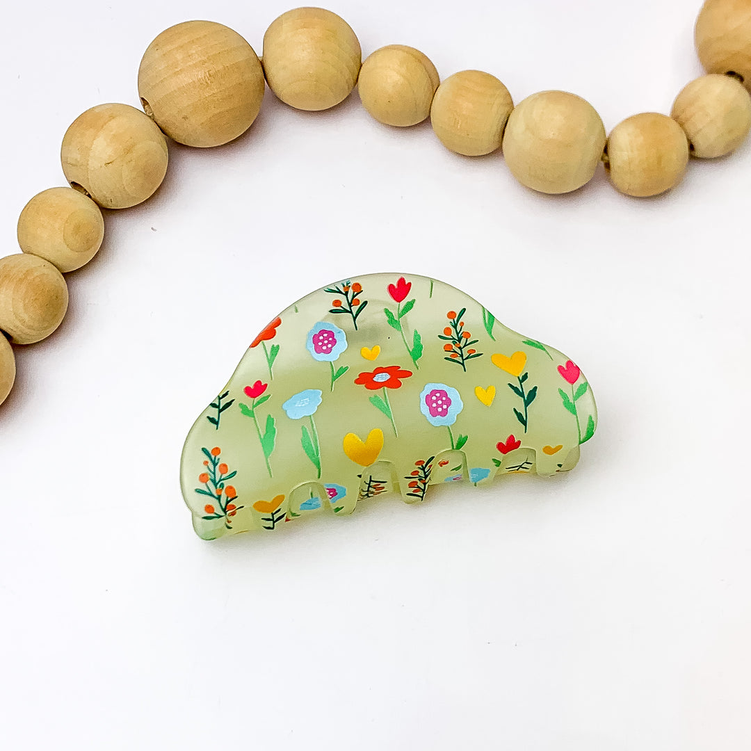 Flower Patch Hair Clip With Flowers in Multicolor. Pictured on a white background with wood beads above the clip.