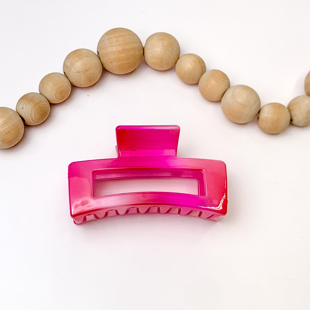 Girly Girl Hair Clips In Pink Marble. Pictured on a white background with wood beads above the clip.