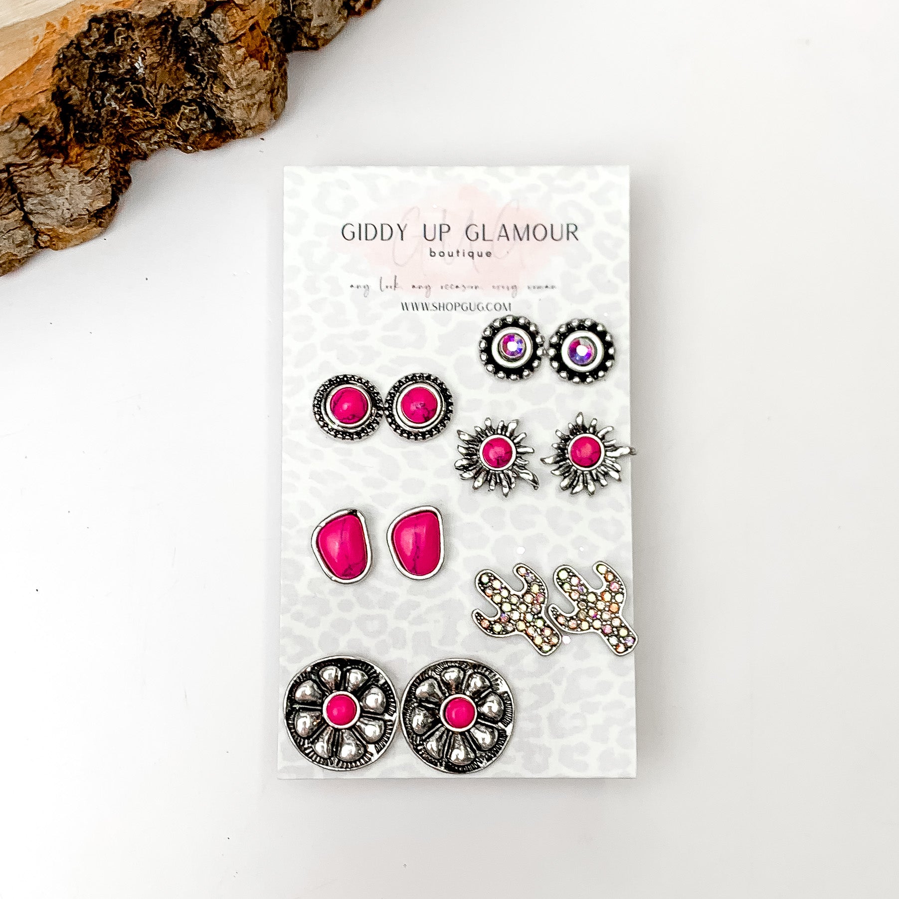 Set Of Six | Western Flower Fuchsia Pink and Silver Tone Stud Earrings. Pictured on a white background with a wood piece in the top left corner.
