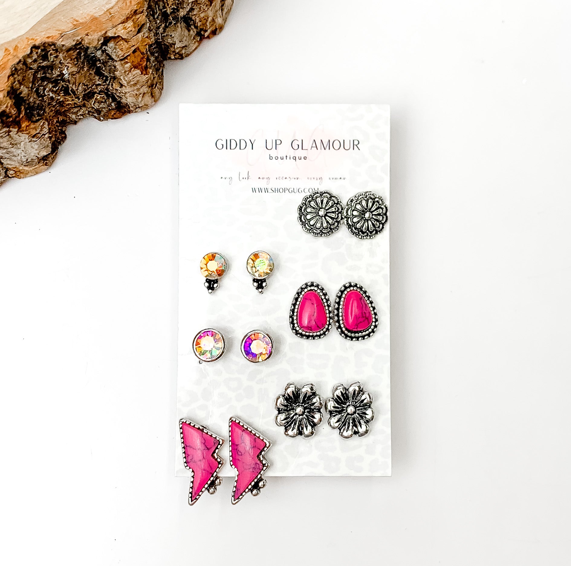 Set Of Six | Western Lightning bolt Fuchsia Pink and Silver Tone Stud Earrings. Pictured on a white background with a wood piece in the top left corner.