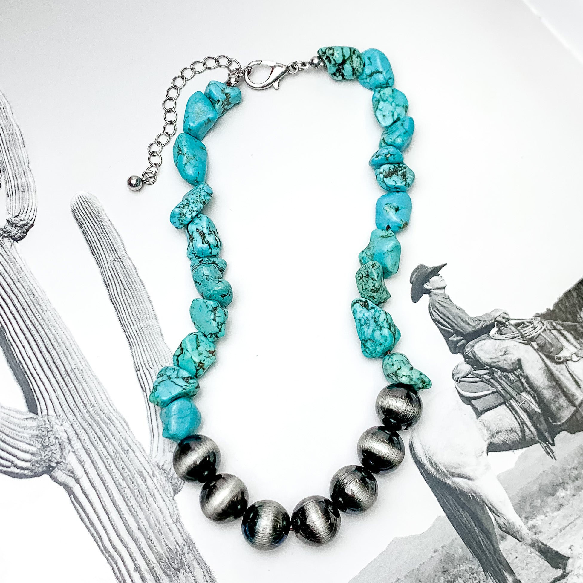 Turquoise Stone Necklace With Silver Tone Beads. Pictured on a western background.