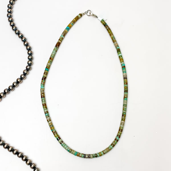 Turquoise green chip necklace pictured on a white background with silver beads on the left side. 