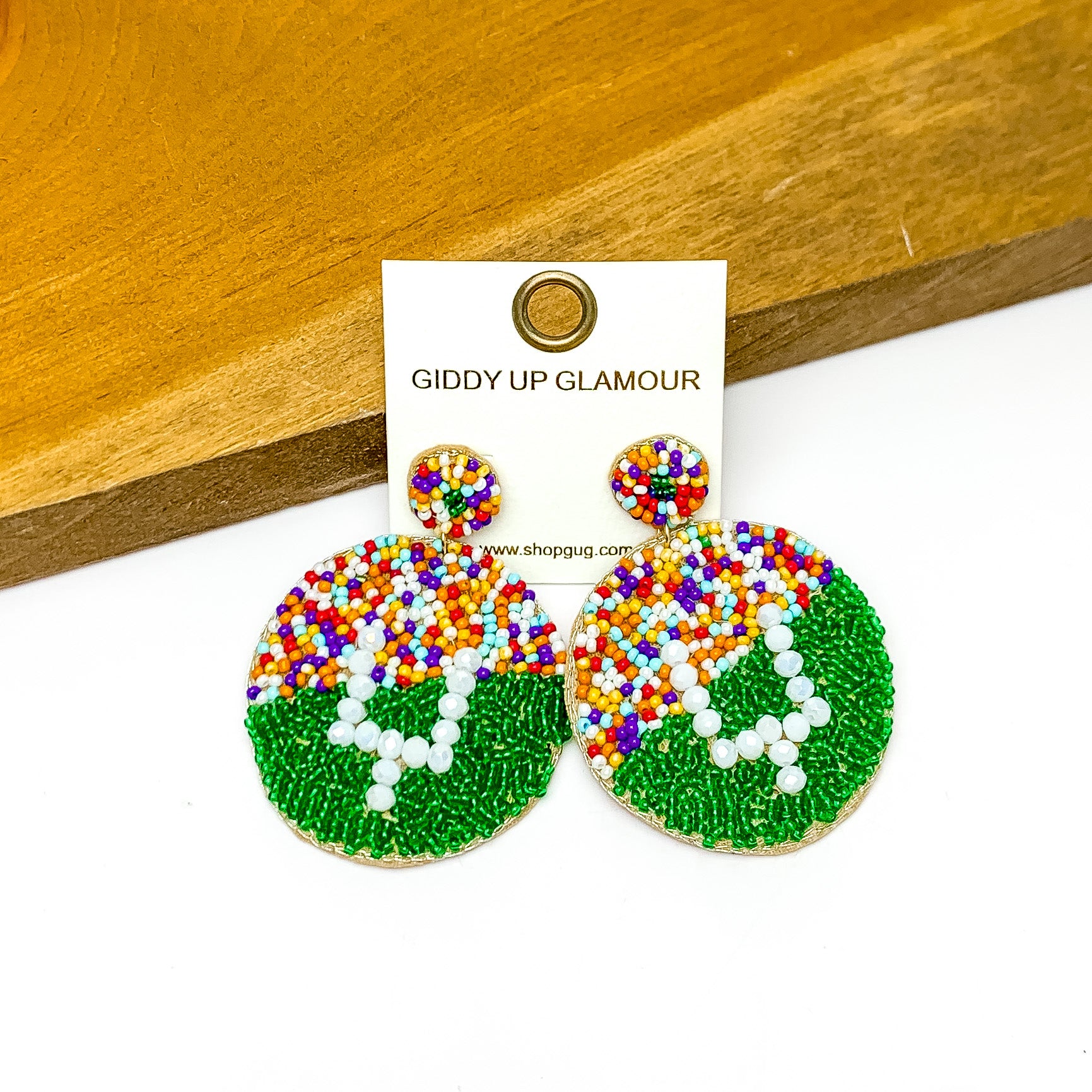 Football Stadium With Field Goal Circular Post Beaded Earrings in Multicolor. Pictured against a wood piece on a white background.