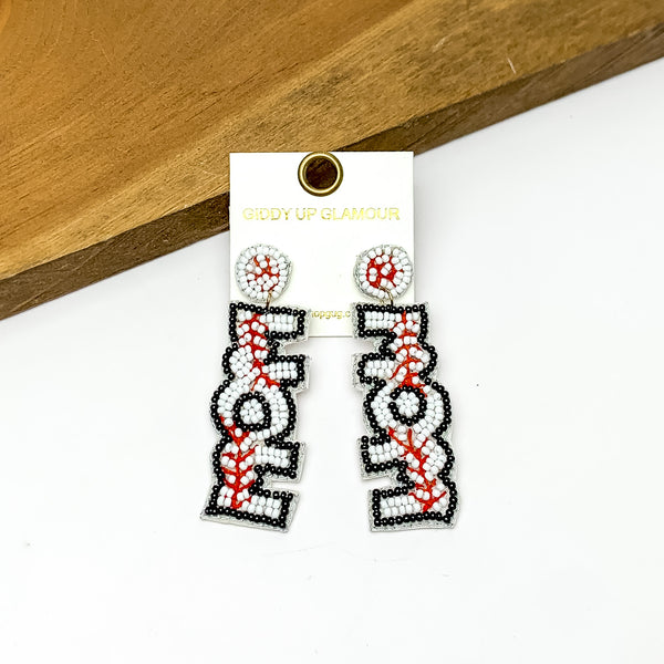 Baseball Mom Circular Beaded Earrings in White and Black. Pictured on a white background with the earrings against a wood piece.