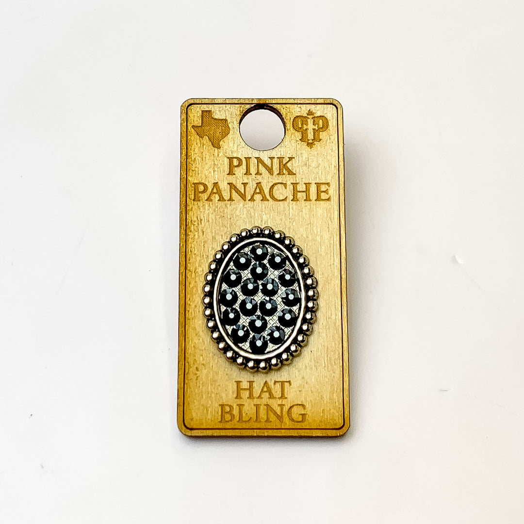 Silver, oval hat pin with a back crystal inlay. This hat pin is pictured on a wooden Pink Panache holder on a white background. 