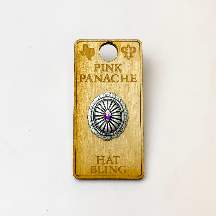 Silver, oval concho hat pin with a center ab crystal. This hat pin is pictured on a wooden Pink Panache holder on a white background. 