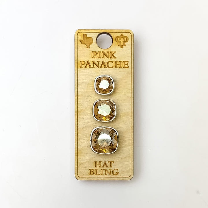Three silver, square hat pins going smallest to biggest with golden shadow cushion cut crystal. This hat pin is pictured on a wooden Pink Panache holder on a white background.
