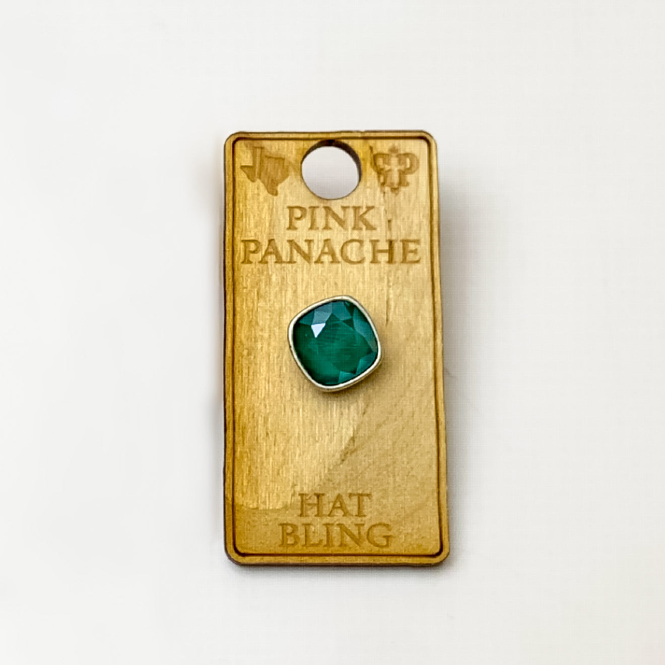 Silver, square hat pin with a royal green cushion cut crystal. This hat pin is pictured on a wooden Pink Panache holder on a white background.