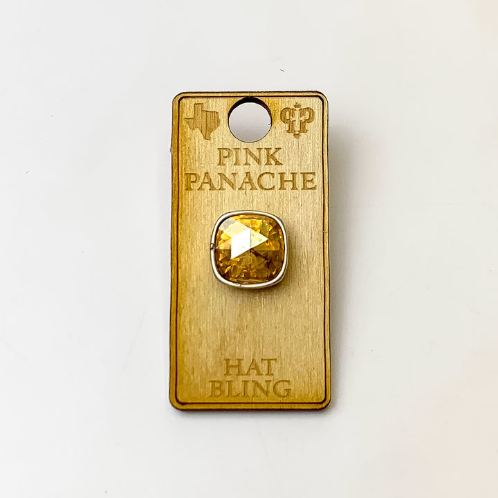 Silver, square hat pin with a light silk cushion cut crystal. This hat pin is pictured on a wooden Pink Panache holder on a white background.