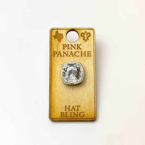 Silver, square hat pin with a clear cushion cut crystal. This hat pin is pictured on a wooden Pink Panache holder on a white background.