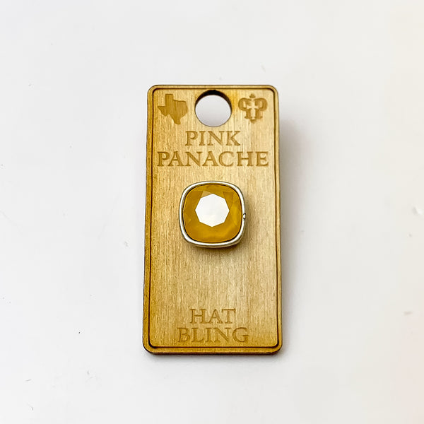 Silver, square hat pin with a Buttercup Yellow cushion cut crystal. This hat pin is pictured on a wooden Pink Panache holder on a white background.