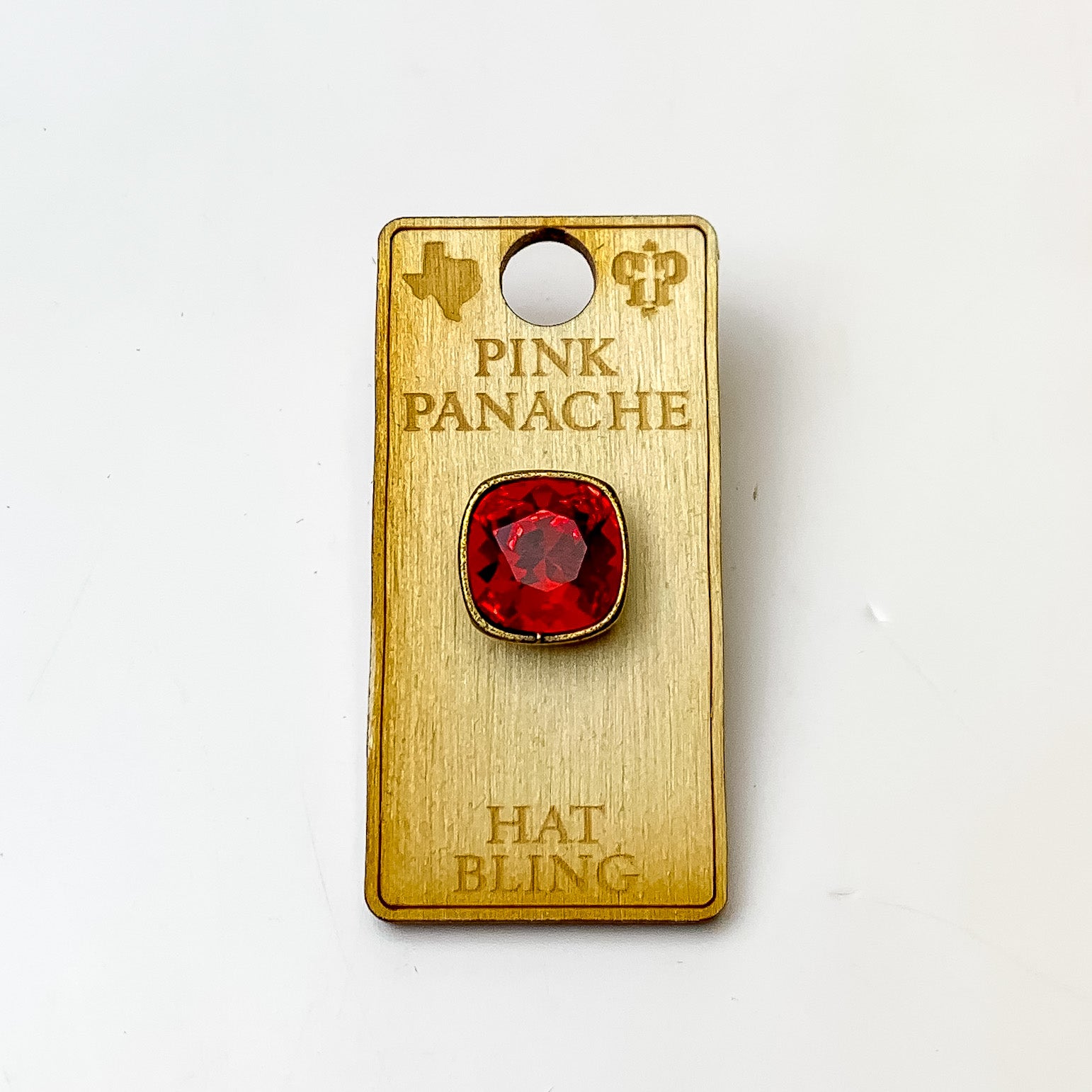 Bronze, square hat pin with a light siam cushion cut crystal. This hat pin is pictured on a wooden Pink Panache holder on a white background.