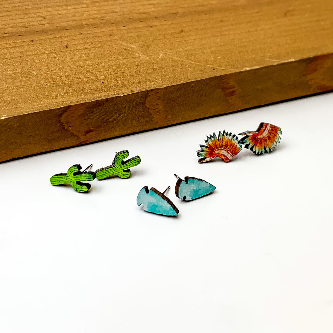 Set Of Three | Wild West Themed Stud Earrings. Pictured on a white background with a wood piece above the earrings.