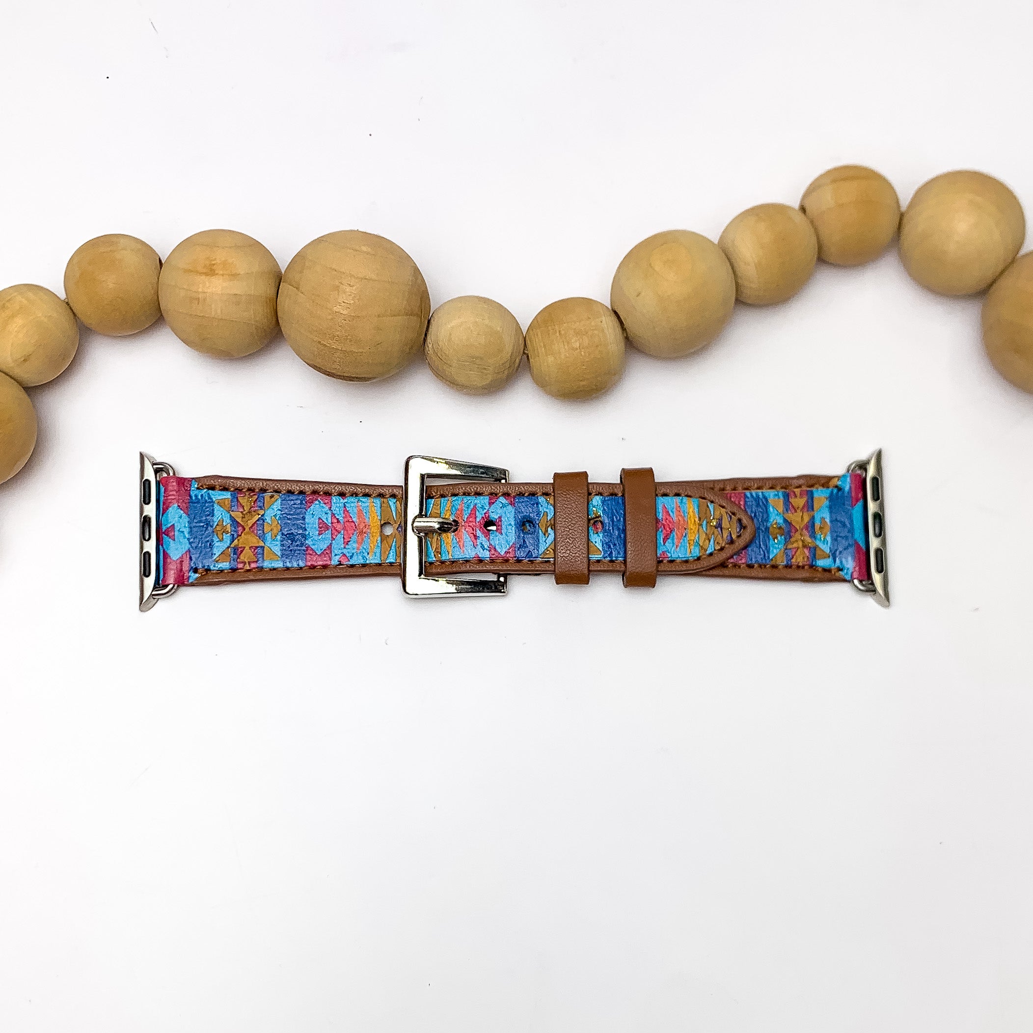 Tribal Printed Apple Watch Band in Blue Multicolor. Pictured on a white background with wood beads above the band for decoration.