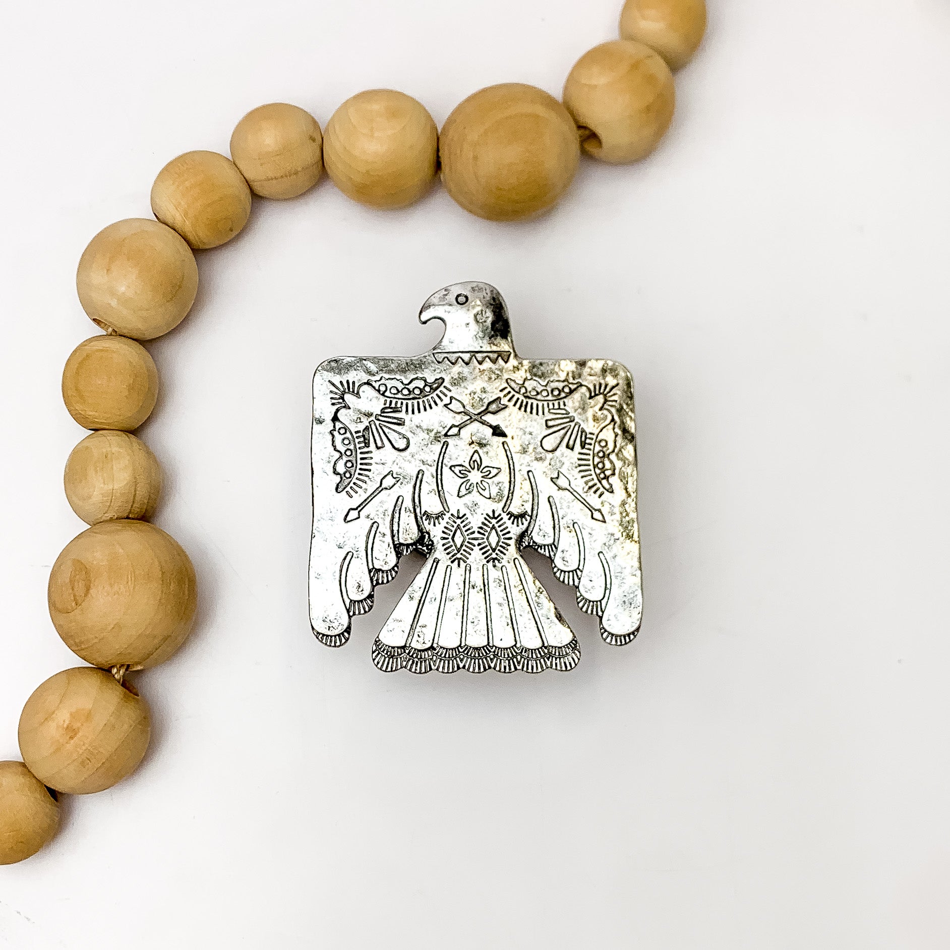 Thunderbird Phone Grip in Silver Tone. Pictured on a white background with wood beads on the side for decoration.